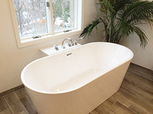 Closeup of beautiful white porcelain freestanding tub installed during bathroom remodel