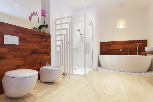 Chic bathroom remodel with freestanding toilets and a white freestanding tub