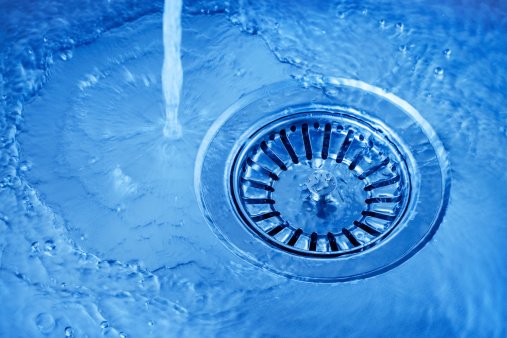 Water running and flowing down a kitchen drain in Rochester, MN